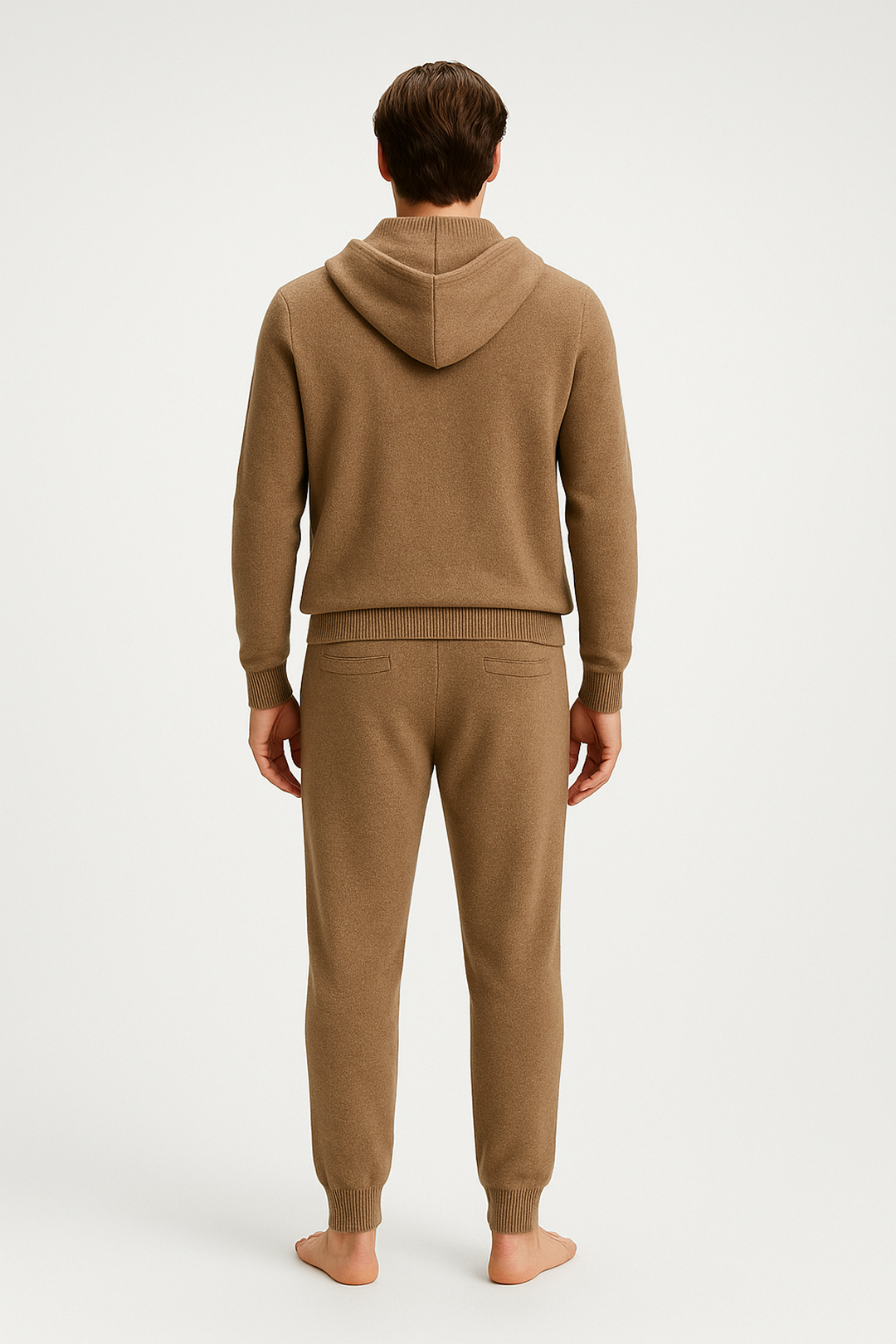 Person wearing a beige hoodie and pants on a white background