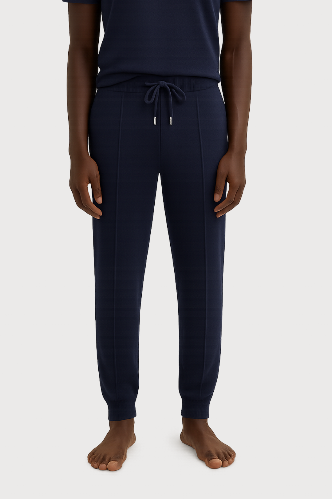 Person wearing navy blue jogger pants on a white background