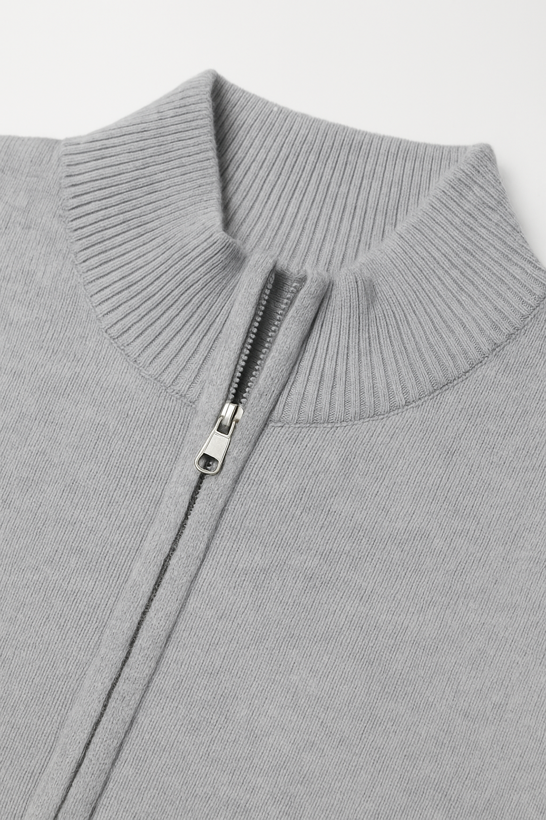Close-up of a gray sweater with a zipper on a light gray background