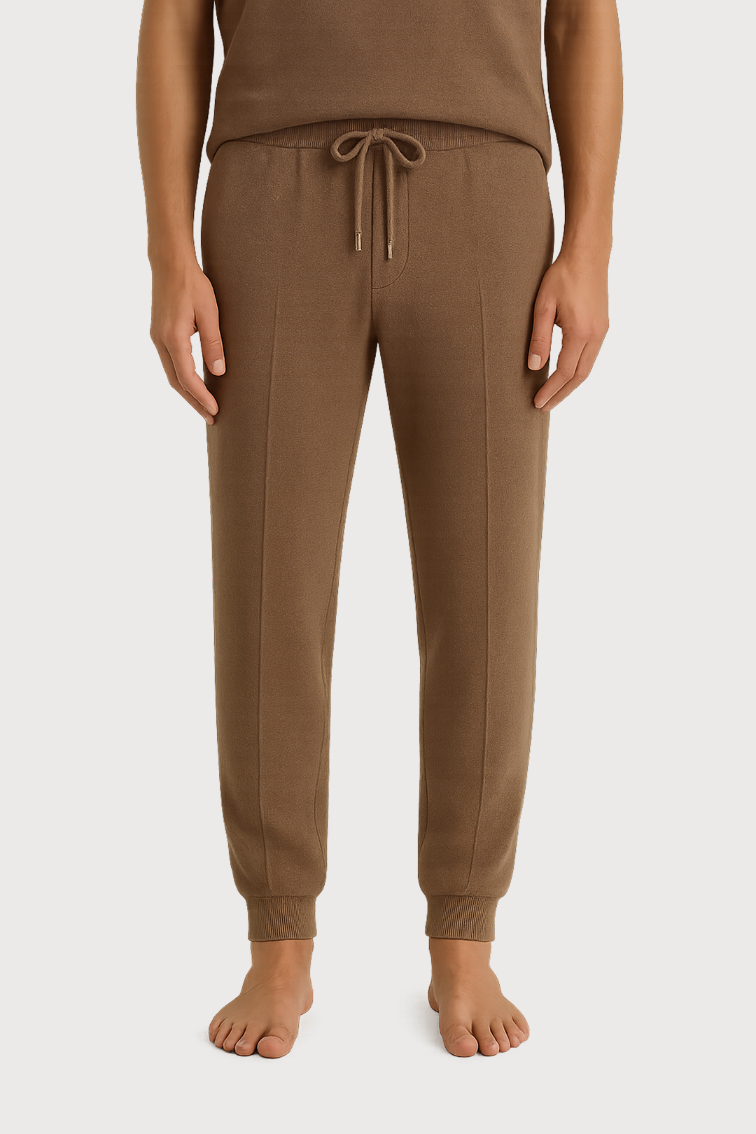 Brown jogger pants worn by a person on a white background