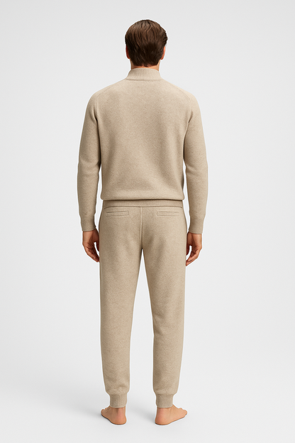 Man wearing a beige sweater and pants on a white background