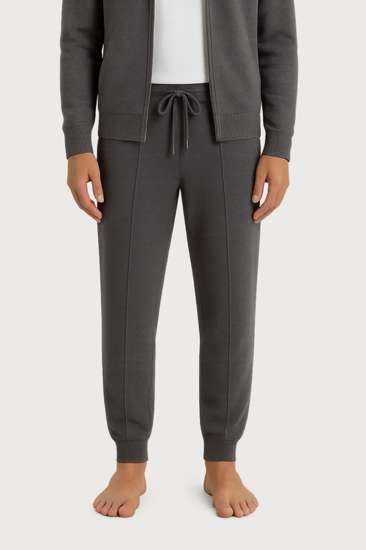 Person wearing a gray tracksuit on a white background