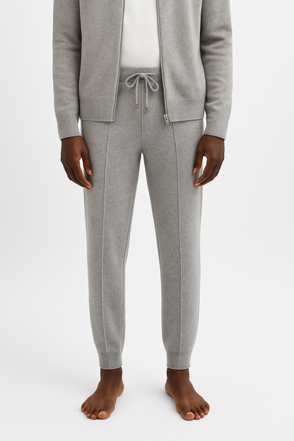 Person wearing gray jogger pants and a matching cardigan on a white background