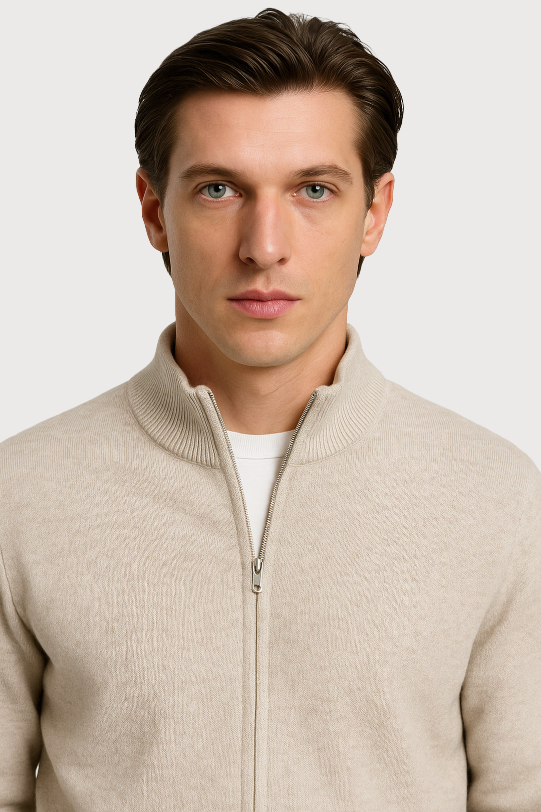 Man wearing a beige zip-up sweater against a white background