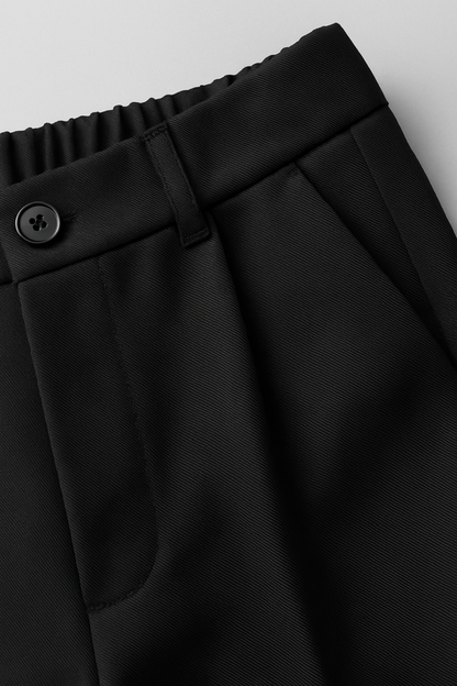 Close-up of black pants with a button on a light gray background