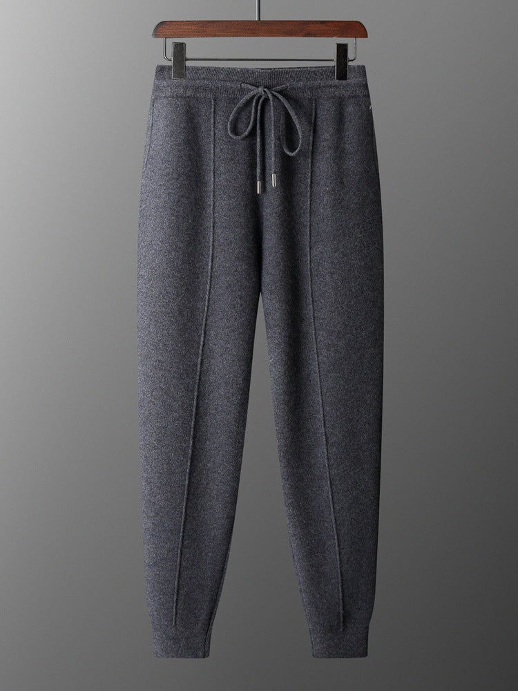 Gray sweatpants on a hanger against a gray background