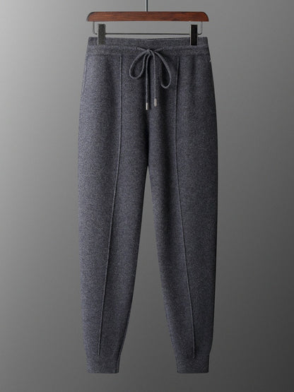 Gray sweatpants on a hanger against a gray background