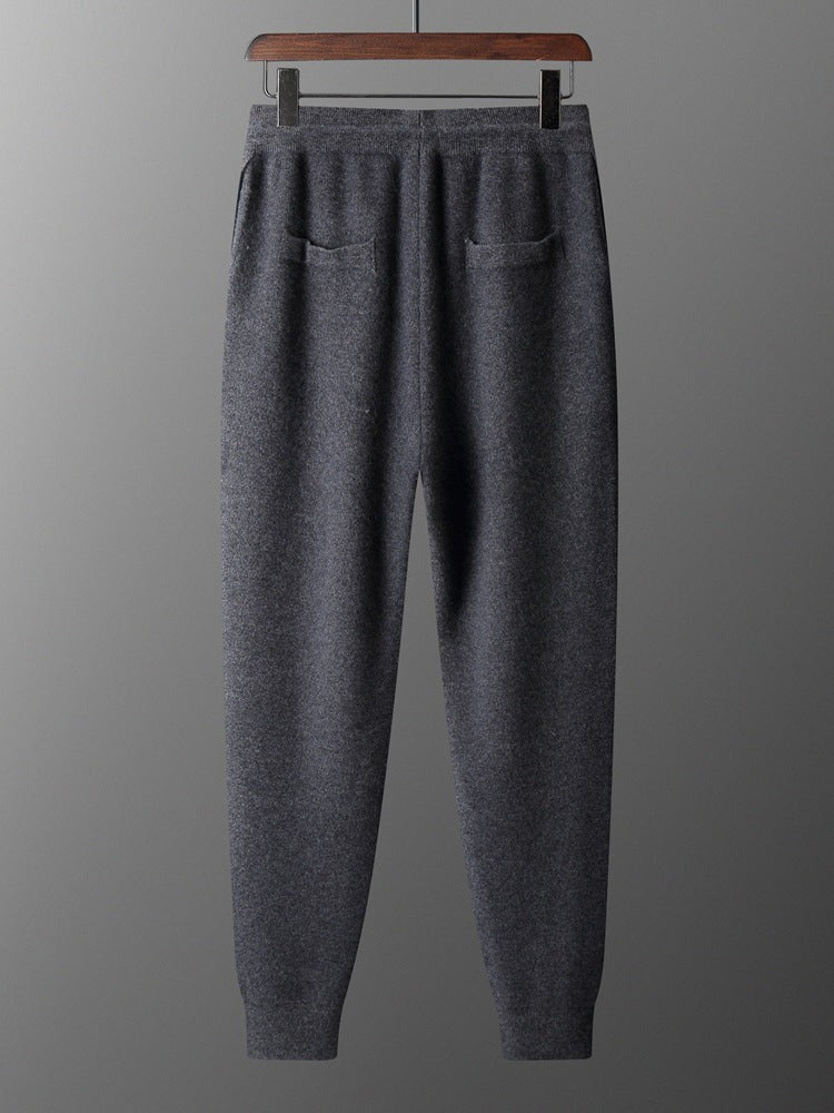 Gray sweatpants on a hanger against a gray background