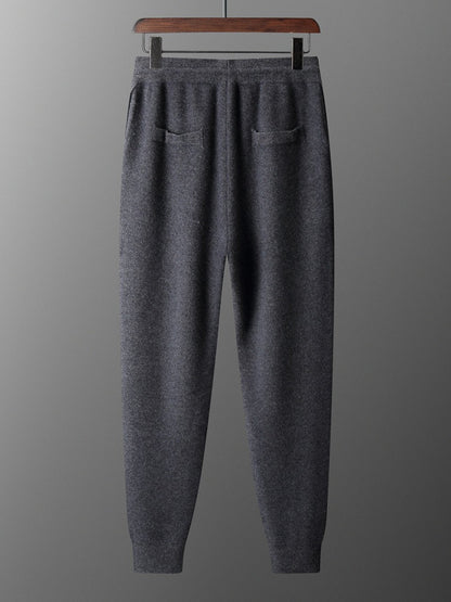 Gray sweatpants on a hanger against a gray background