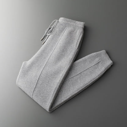 Folded gray sweatpants on a gradient gray background