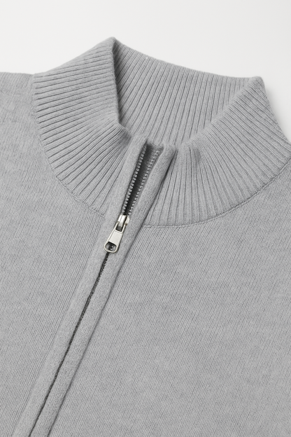 Close-up of a gray sweater with a zipper on a light gray background