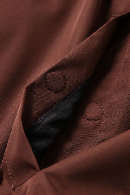 Close-up of a brown jacket with buttons and black lining.