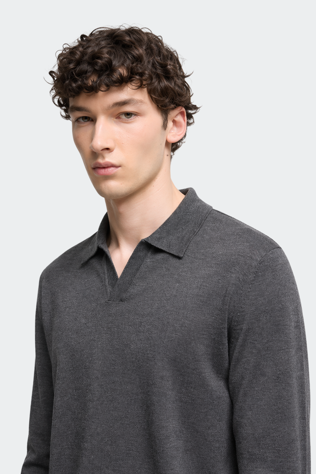 Man wearing a gray sweater with a collar against a white background