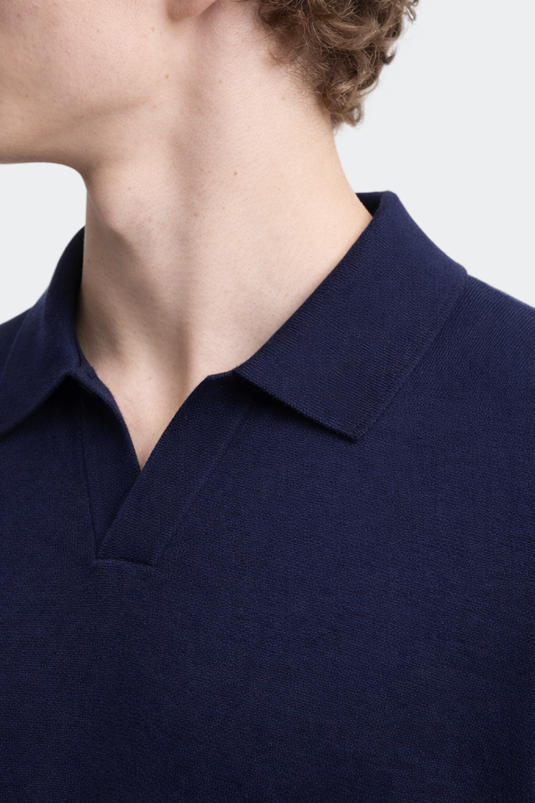 Navy blue polo shirt worn by a person on a light gray background