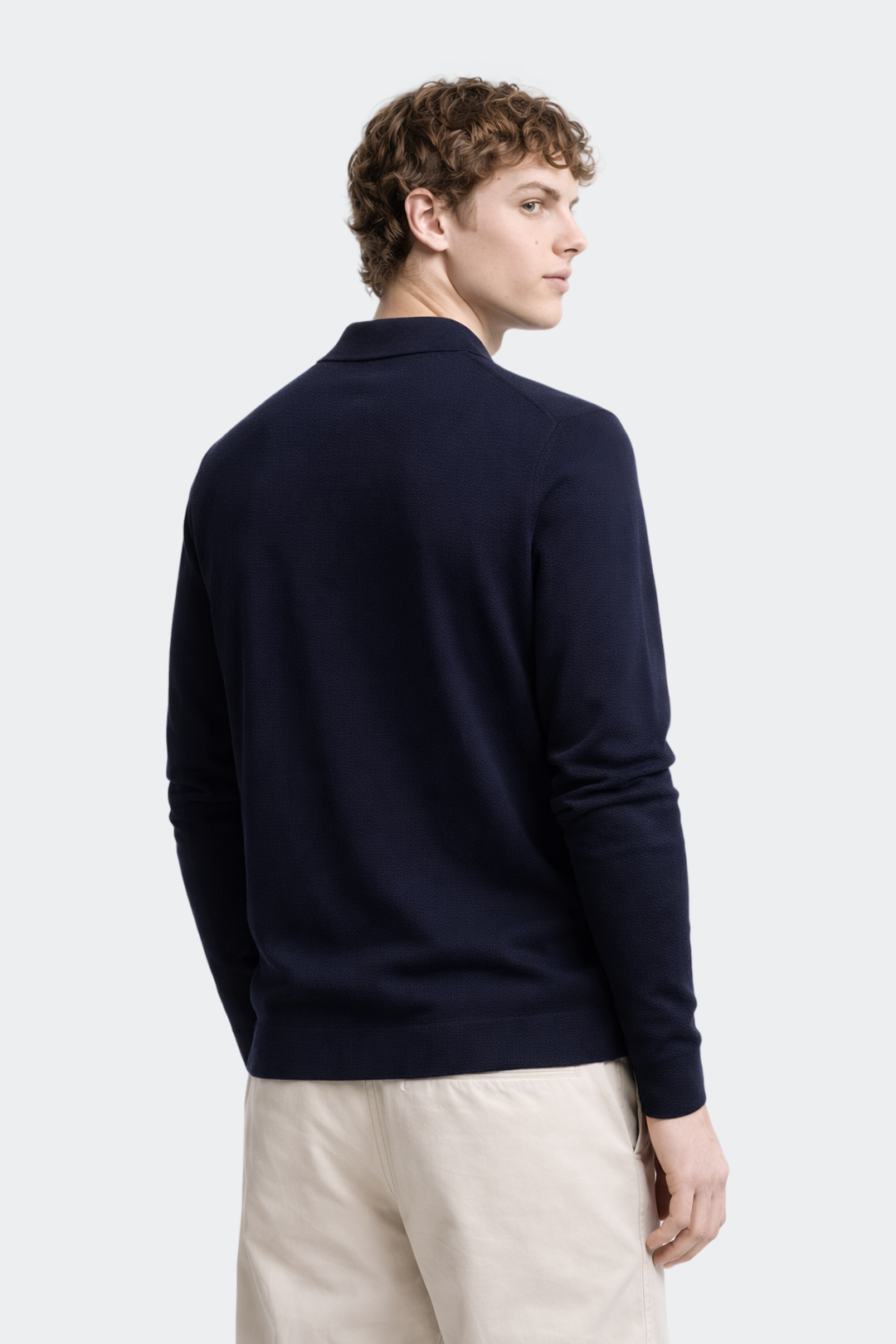 Man wearing a navy blue sweater against a white background