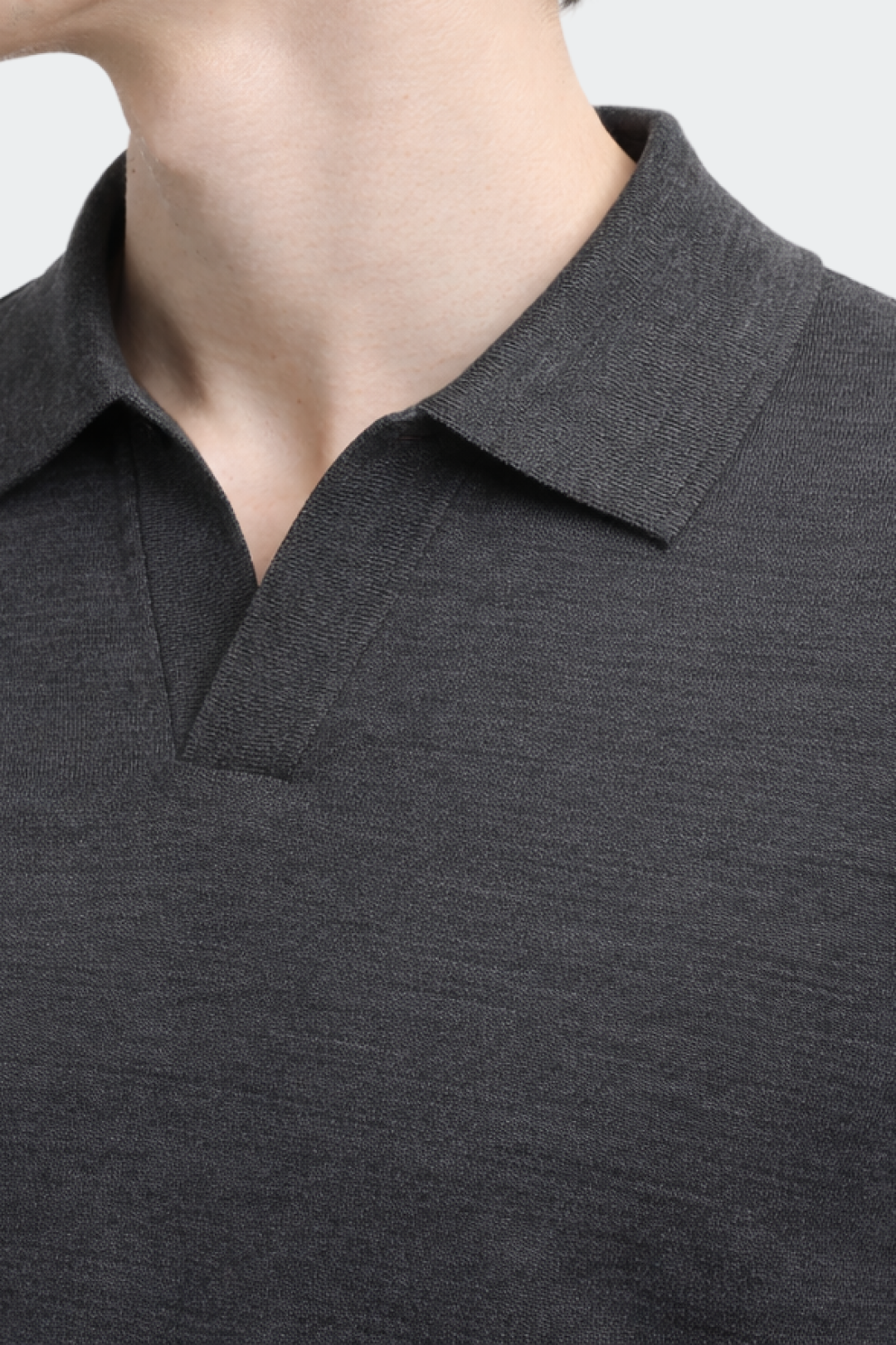 Close-up of a person wearing a dark gray polo shirt with a collar.